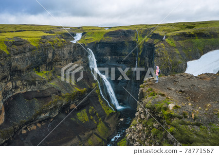 Aerial above view of woman with backpack enjoying icelandic highland and Granni waterfall. Iceland Aerial above view of woman with backpack enjoying icelandic highland and Granni waterfall. Iceland 78771567