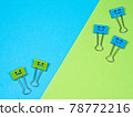 Multicolored paperclip on blue green background 78772216