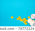 Yellow pills and plastic white bottle 78772224