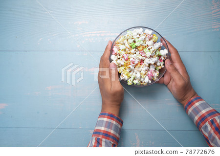young man eating popcorn top view young man eating popcorn top view 78772676