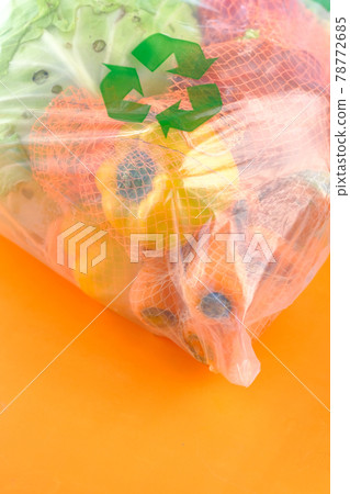 Recycled arrows sign on a shopping bag with vegetable on orange background  78772685