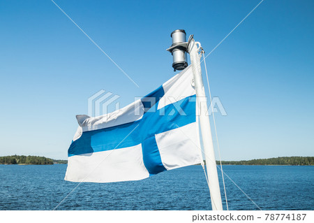 A finnish flag on a boat in the wind on lake Saimaa near the Lappeenranta, Finland 78774187