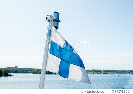 A finnish flag on a boat in the wind on lake Saimaa near the Lappeenranta, Finland 78774192