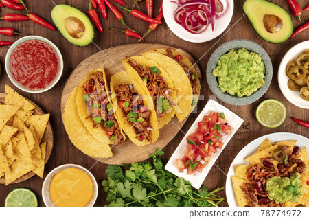 A photo of Mexican food, including tacos, guacamole, pico de gallo, nachos etc 78774972