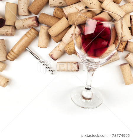 Glass of red wine with corks and corkscrew on a white background with copy space, top shot 78774995