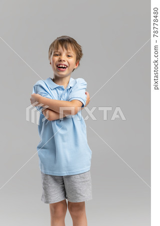 Full-length portrait of Caucasian little boy posing isolated over gray studio background. Full-length portrait of Caucasian little boy posing isolated over gray studio background. 78778480