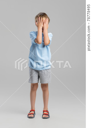 Full-length portrait of Caucasian little boy posing isolated over gray studio background. Full-length portrait of Caucasian little boy posing isolated over gray studio background. 78778495