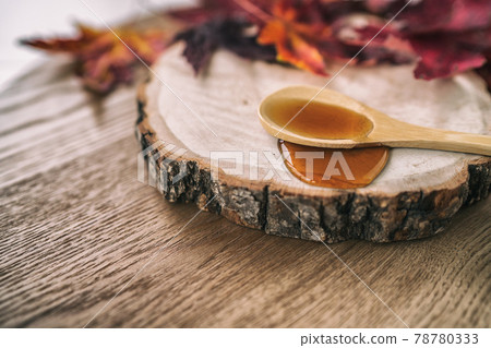 Maple syrup sugar liquid in wooden spoon from Quebec restaurant sugar shack called Cabane a sucre maple trees sap farm. Canadian delicacy sweet dessert ingredient Maple syrup sugar liquid in wooden spoon from Quebec restaurant sugar shack called Cabane a sucre maple trees sap farm. Canadian delicacy sweet dessert ingredient 78780333