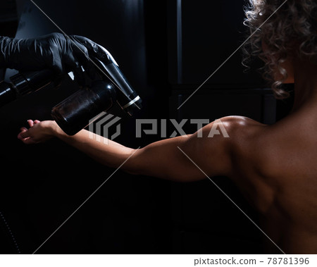 The master applies tinting paint to the woman's hand. Instant tanning procedure The master applies tinting paint to the woman's hand. Instant tanning procedure 78781396