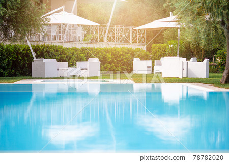 Blue outdoor swimming pool with beach umbrellas 78782020