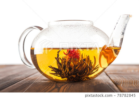 Bound tea in transparent teapot on wooden background. 78782845