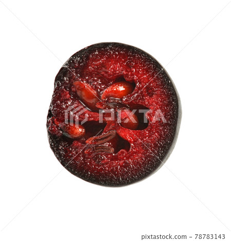 Single aronia (chokeberry) fruit cut in half, red pulp and seeds visible, isolated on white background. 78783143