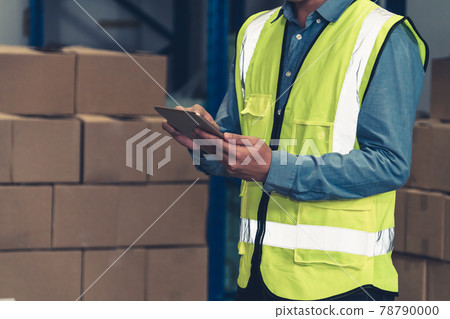 Asian warehouse worker checking packages in storehouse Asian warehouse worker checking packages in storehouse 78790000