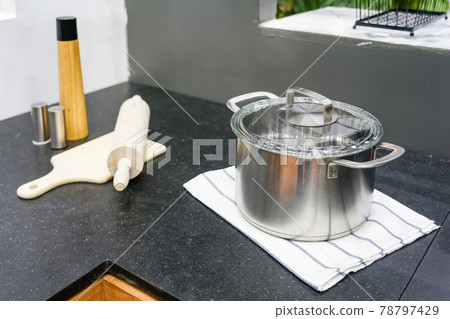 Stainless steel pot on a granite counter top in modern kitchen room Stainless steel pot on a granite counter top in modern kitchen room 78797429