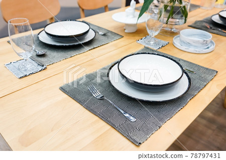 modern ceramic tableware in dining room with table set ready for a nice meal modern ceramic tableware in dining room with table set ready for a nice meal 78797431