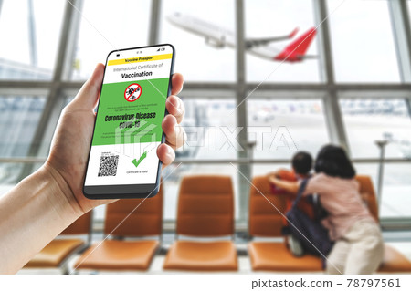 Traveler holds vaccine passport certificate to show COVID 19 vaccination status 78797561