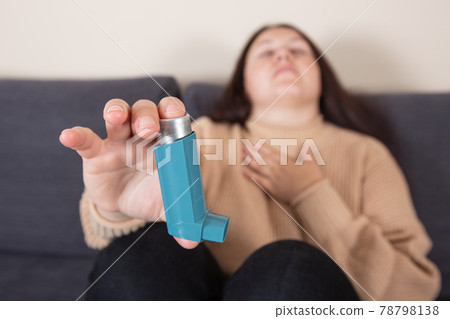 Young woman looking for an asthma inhaler during strong asthma attack, cannot breathing, healthcare concept 78798138