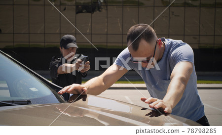 Female police officer arresting male driver 78798285