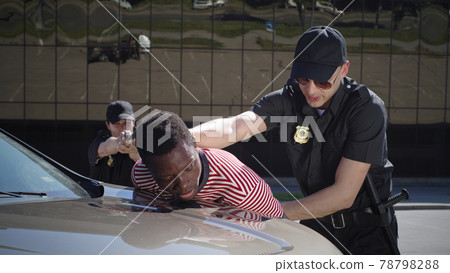 Police officers with gun arresting black driver 78798288