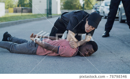 Diverse police officers arresting African American man 78798346
