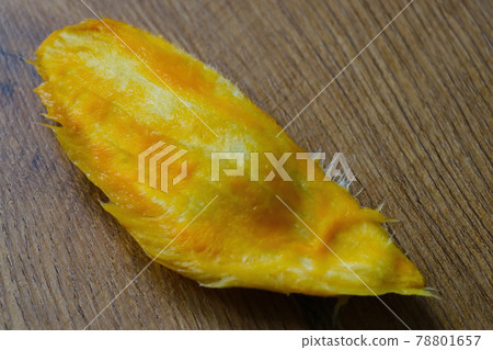 A long bone from a mango lies on the table. A long bone from a mango lies on the table. 78801657