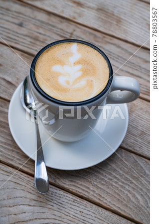 cup with a cappuccino on a wooden table. Delicious coffee cup with a cappuccino on a wooden table. Delicious coffee 78803567