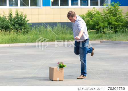 Enraged man kicks a box of personal belongings after being fired 78804750