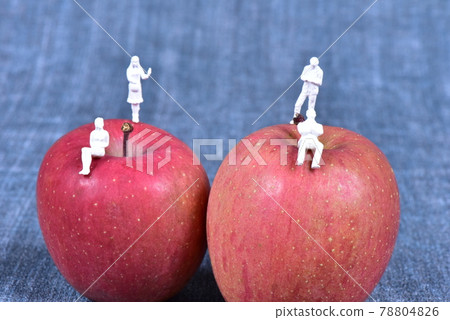 Doll standing on an apple Doll standing on an apple 78804826