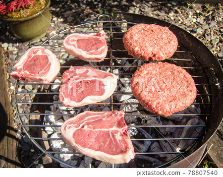 Hamburger and lamb chops grilled on charcoal on a barbecue set 78807540