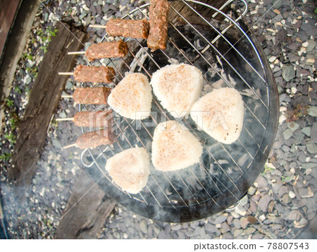 Grilled rice balls and lamb cuffs that are charcoal-grilled on a smoke-raising barbecue set Grilled rice balls and lamb cuffs that are charcoal-grilled on a smoke-raising barbecue set 78807543