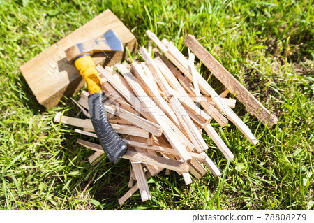Firewood with an ax on the green grass in summer. Firewood with an ax on the green grass in summer. 78808279