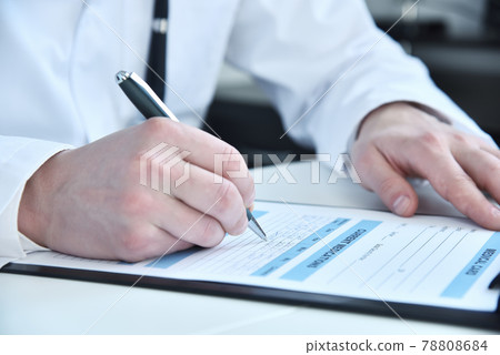 Doctor writing on clipboard in medical office 78808684