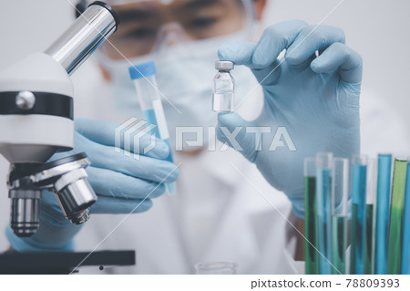 Close Up man doctor or scientist in uniform wearing a face mask with a stethoscope holding COVID-19 vaccine, Healthcare And Medical concept, vaccine Concept fight against virus covid-19 . 78809393
