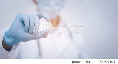 Close Up man doctor or scientist in uniform wearing face mask with a stethoscope holding COVID-19 vaccine, Healthcare And Medical concept, vaccine Concept fight against virus covid-19 corona virus 78809404