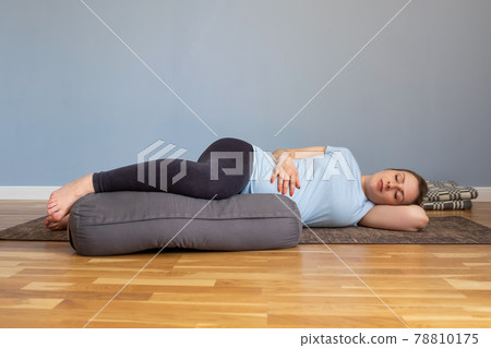 Pregnant woman lying in Shavasana, resting after practice, meditating 78810175