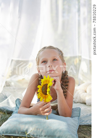 Little girl in white chiffon tent with sunflower Little girl in white chiffon tent with sunflower 78810229
