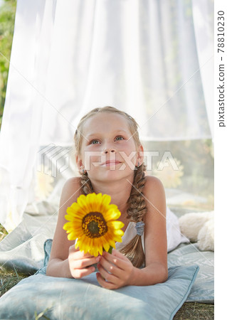 Little girl in white chiffon tent with sunflower Little girl in white chiffon tent with sunflower 78810230