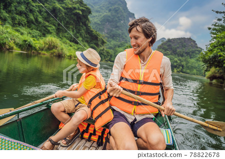 Happy family tourists in Trang An Scenic Landscape Complex in Ninh Binh Province, Vietnam A UNESCO World Heritage Site. Resumption of tourism in Vietnam after quarantine Coronovirus COVID 19 78822678