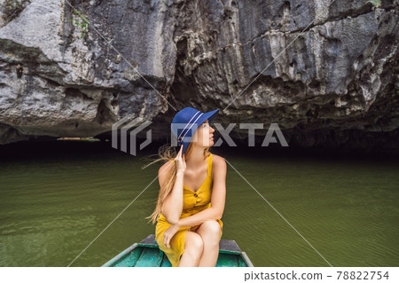 Woman tourist in boat on the lake Tam Coc, Ninh Binh, Viet nam. It's is UNESCO World Heritage Site, renowned for its boat cave tours. It's Halong Bay on land of Vietnam. Vietnam reopens borders after Woman tourist in boat on the lake Tam Coc, Ninh Binh, Viet nam. It's is UNESCO World Heritage Site, renowned for its boat cave tours. It's Halong Bay on land of Vietnam. Vietnam reopens borders after 78822754