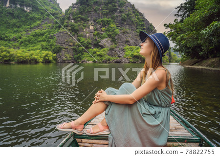 Woman tourist in Trang An Scenic Landscape Complex in Ninh Binh Province, Vietnam A UNESCO World Heritage Site. Resumption of tourism in Vietnam after quarantine Coronovirus COVID 19 Woman tourist in Trang An Scenic Landscape Complex in Ninh Binh Province, Vietnam A UNESCO World Heritage Site. Resumption of tourism in Vietnam after quarantine Coronovirus COVID 19 78822755