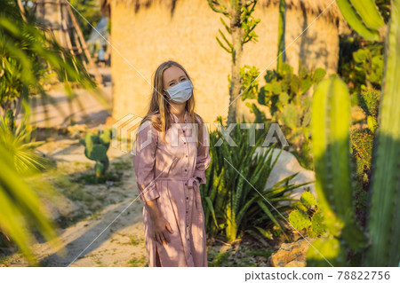 beautiful stylish young woman in pink dress in desert among the cacti, wearing a medical mask during COVID-19 coronavirus, traveling in Africa on safari, exploring nature, sunny summer, traveler on beautiful stylish young woman in pink dress in desert among the cacti, wearing a medical mask during COVID-19 coronavirus, traveling in Africa on safari, exploring nature, sunny summer, traveler on 78822756