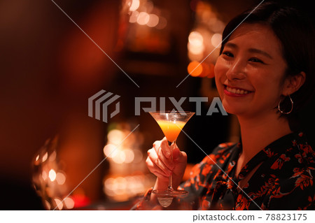 Woman drinking at the bar 78823175