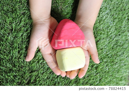 A house with a red roof in the palm of a child at Kaminedo 78824415