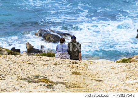 Two people sitting near the ocean beach with... - Stock Photo [78827548] -  PIXTA