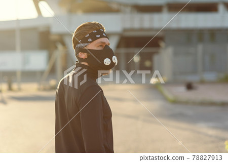 healthy and handsome young man running at the cityspace. The man wearing a respirator for cardio training. healthy and handsome young man running at the cityspace. The man wearing a respirator for cardio training. 78827913