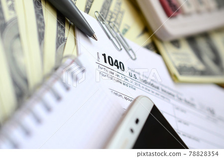 The pen, notebook, calculator, smartphone and dollar bills is lies on the tax form 1040 U.S. Individual Income Tax Return. The time to pay taxes The pen, notebook, calculator, smartphone and dollar bills is lies on the tax form 1040 U.S. Individual Income Tax Return. The time to pay taxes 78828354