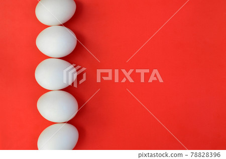 A few white eggs on a bright red background A few white eggs on a bright red background 78828396