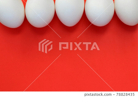A few white eggs on a bright red background 78828435