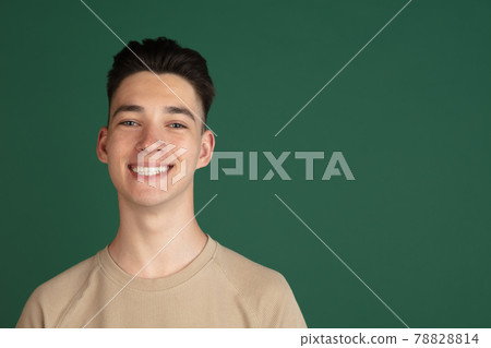 Portrait of young Caucasian boy isolated on green studio background. Concept of facial expressions, human emotions. Portrait of young Caucasian boy isolated on green studio background. Concept of facial expressions, human emotions. 78828814