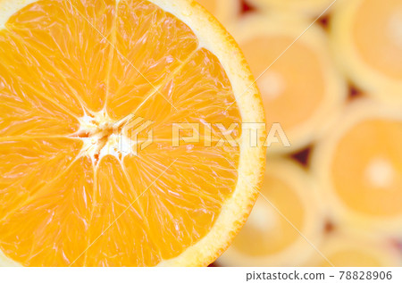 Top view of a fragment of the orange fruit slice on the background of many blurred orange slices. A saturated citrus texture image Top view of a fragment of the orange fruit slice on the background of many blurred orange slices. A saturated citrus texture image 78828906